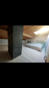 a room with a bed and a brick wall at Appartement 4 personnes in Briançon