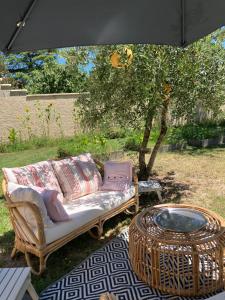 ein Sofa und einen Tisch unter einem Schirm in der Unterkunft Maison circé in Loupiac-de-Cadillac