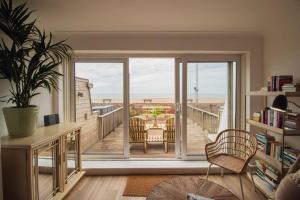 d'un salon avec une grande porte coulissante en verre et un balcon. dans l'établissement The Beach Box By Air Premier, à Seaford