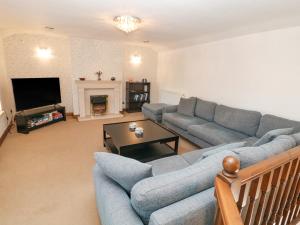 a living room with a couch and a tv at Querc in Stoney Middleton