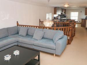 a living room with a blue couch and a table at Querc in Stony Middleton