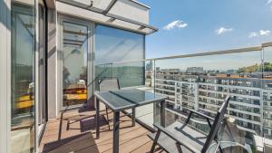 balkon ze stołem i krzesłami na budynku w obiekcie Plac Unii, Sun & Snow w mieście Gdynia