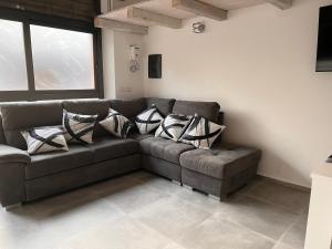 a living room with a brown couch with pillows at Urban charme loft in Dorgali