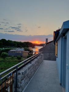 a sunset from the balcony of a building with a view of a river at Robinson house T'n'T in Hvar