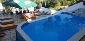 a large blue swimming pool with a green umbrella at Apartment Bradex Dreams in Becici