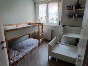 een kleine kamer met 2 stapelbedden en een stoel bij Appartamento Tranquillo con Giardino in Morbegno