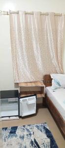 a small bedroom with a bed and a window at RÈSIDENCE NGUARY in Dakar