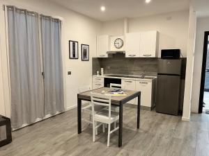 a small kitchen with a table and a refrigerator at Emma House in Bellano