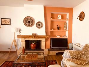 a living room with a fireplace and a tv at VILLA TAPÔA - Maison au coeur de Marseillan in Marseillan