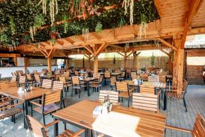 an empty restaurant with wooden tables and chairs at Montana Garden in Răşinari