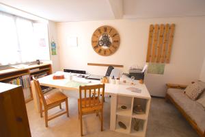 a living room with a table and a clock on the wall at Chalet Cuore delle Alpi in Airolo