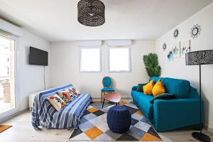 ein Wohnzimmer mit einem blauen Sofa und einem Stuhl in der Unterkunft Le Palmier Vert - Magnifique T2 à Montpellier- Balcon 16m2 - CLIM -WIFI in Montpellier