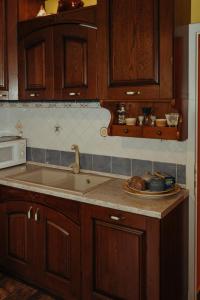 eine Küche mit Holzschränken und einem Waschbecken in der Unterkunft Casa Caracciolo in Pitigliano
