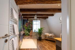 a bathroom with a glass shower in a room with wooden ceilings at Flair Hotel Hopfengarten in Miltenberg