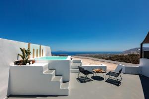 a view of a balcony with chairs and a table at Lackos Luxury Suites in Imerovigli
