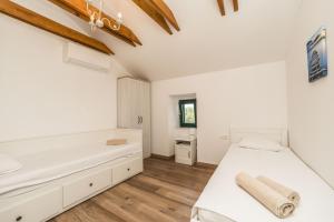 1 dormitorio con 2 camas y bañera en Stone House Luna en Poljana