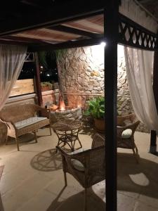 a patio with wicker chairs and a stone fireplace at No Vabbè! Penthouse… in Torre Santa Susanna +87 photos