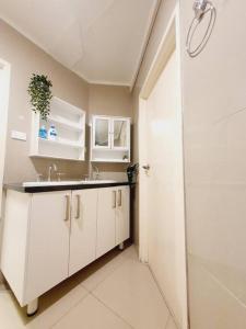 biała łazienka z umywalką i prysznicem w obiekcie Architectural Bright open place with a private garden at Yarralumla w mieście Yarralumla