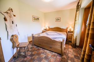 a bedroom with a wooden bed and a chair at ECO Tourist Farm Kostanje in Sevnica