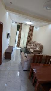 a living room with two couches and a table at Star Max Apartments in Kigali