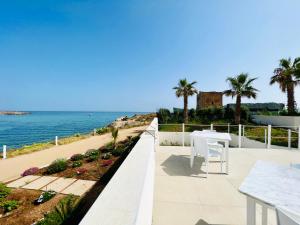 balcón con mesa y vistas al océano en Torre Pozzillo Beach, en Cinisi