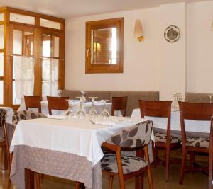 een eetkamer met een witte tafel en stoelen bij badain in La Fortunada