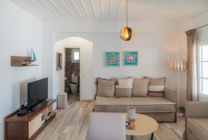 sala de estar con sofá y TV en Erifili Houses, en Faros