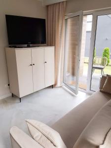 a living room with a tv and a white cabinet at Apartament Jastrzębia Góra 12 B in Władysławowo