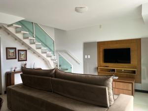 sala de estar con sofá, TV y escaleras en MIRANTE DE ESCARPAS 1704 en Capitólio