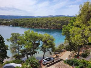 a van parked on a beach next to a river at Apartment Bugenvila in Vrboska