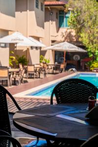 a table and chairs next to a swimming pool at Hotel 365 in Cuiabá