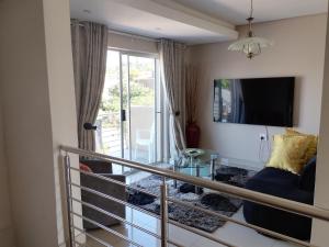 a living room with a couch and a television at Malusi Bed and Breakfast in Verulam