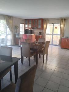 a kitchen and dining room with a table and chairs at Malusi Bed and Breakfast in Verulam