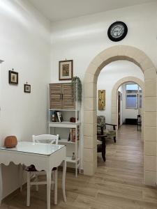 a living room with a table and a clock on the wall at Villa Mimina in San Pietro in Bevagna