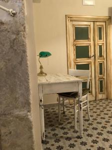 a white desk with a green lamp and a chair at Kasatò B&B in Siculiana