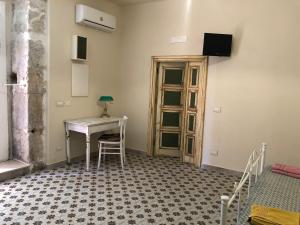 a room with a desk and a table and a window at Kasatò B&B in Siculiana