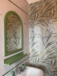 a bathroom with a green mirror and a sink at NICE - camere con bagno privato in Lioni