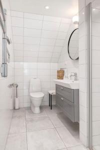 Baño blanco con aseo y lavamanos en Visby city Apartments, en Visby
