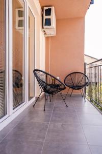 twee stoelen op het balkon van een huis bij The White Lotus Apartment in Ohrid