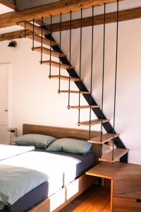 a bedroom with a bed and a staircase at Kotič na hribu in Dobravlje