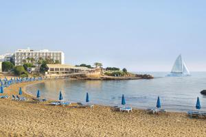 - une plage avec des chaises, des parasols et un voilier dans l'établissement Villa Danata, à Protaras