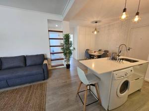 Il dispose d'une cuisine et d'un salon avec un canapé et une table. dans l'établissement Ria Sol Mar Apartment Costa Nova, à Costa Nova