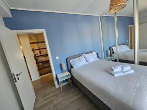 - une chambre bleue avec un lit et des serviettes dans l'établissement Ria Sol Mar Apartment Costa Nova, à Costa Nova