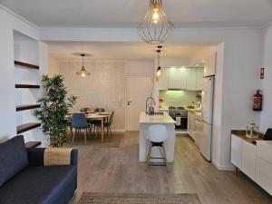 a living room and kitchen with a couch and a table at Ria Sol Mar Apartment Costa Nova in Costa Nova