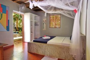 a bedroom with a bed with a mosquito net at Villa Ilo Komba in Nosy Komba