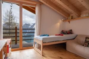 a bedroom with a bed and a large window at Papillon in Bettmeralp