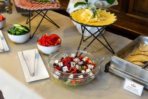 a table topped with a bowl of salad and food at Kamelot in Ternopil