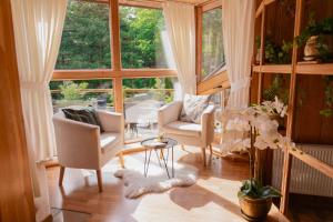 sala de estar con sillas y ventana grande en Willa Chruślice-Basen sezon,Sauna en Nowy Sącz