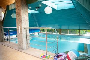 uma piscina com paredes azuis e um tecto azul em Willa Chruślice-Basen sezon,Sauna em Nowy Sącz