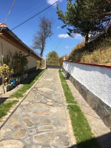 a stone path next to a house with a fence at Cozy Home in Ardino in Ardino